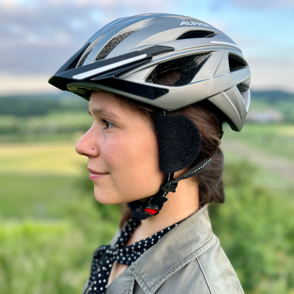 Radfahrerin mit earSHIELD Pro am Fahrradhelm vor dem Ohr im Profil